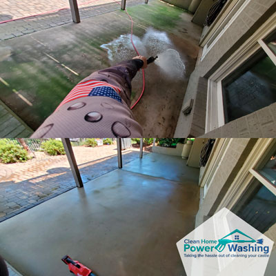 Pressure washing a stained concrete patio to restore clean surface near a brick home