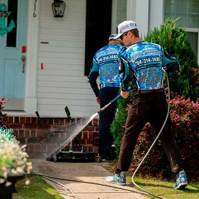 Concrete cleaning team pressure washing front walkway of home in Charlotte NC