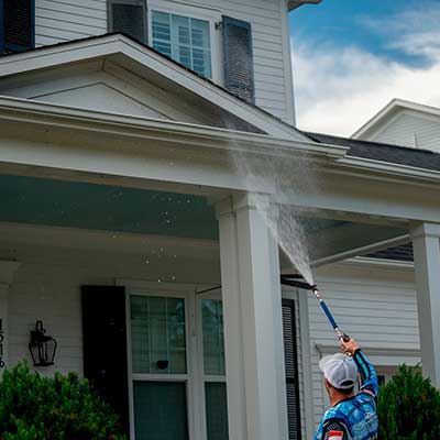 Exterior cleaning technician washing front porch columns of a Charlotte NC home
