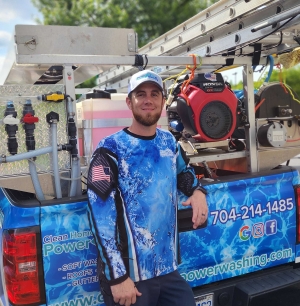 Clean Home Power Washing's owner Raymond stands in front of one of the company trucks
